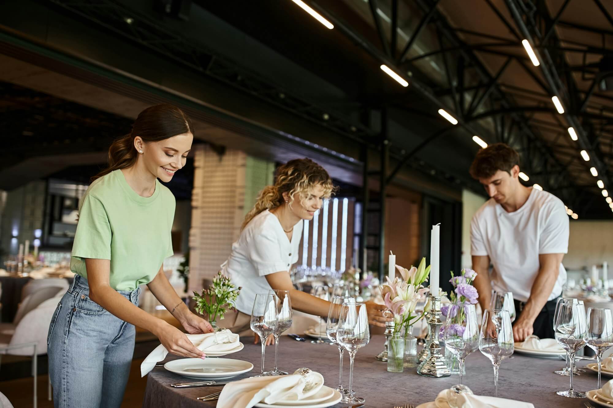 team-of-decorators-organizing-festive-setting-on-table-with-floral-decor-in-celebration-hall.jpg